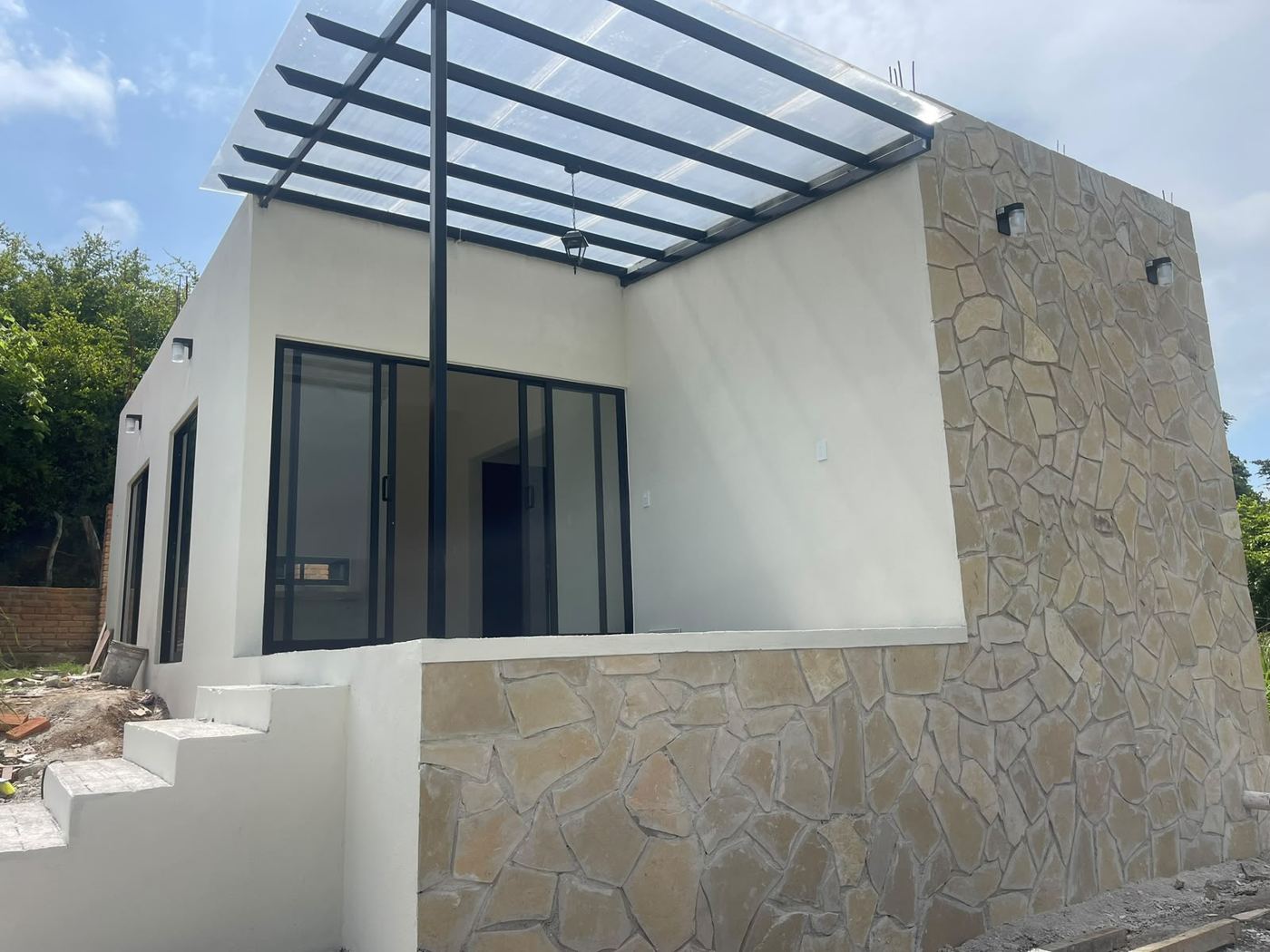 Fachada de piedra y pérgola · Diseño y construcción · Construq